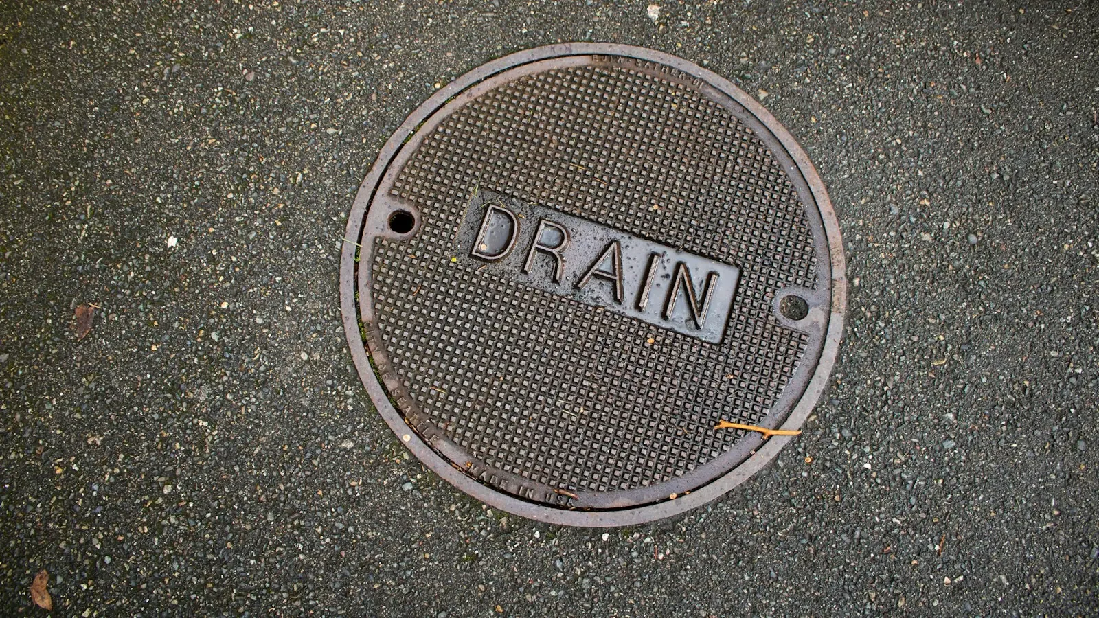 A round DRAIN cover in asphalt